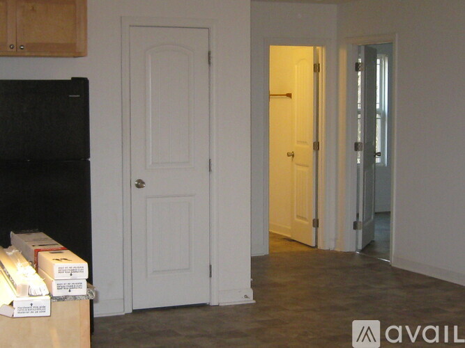 A kitchen with a white door and a black fridge.