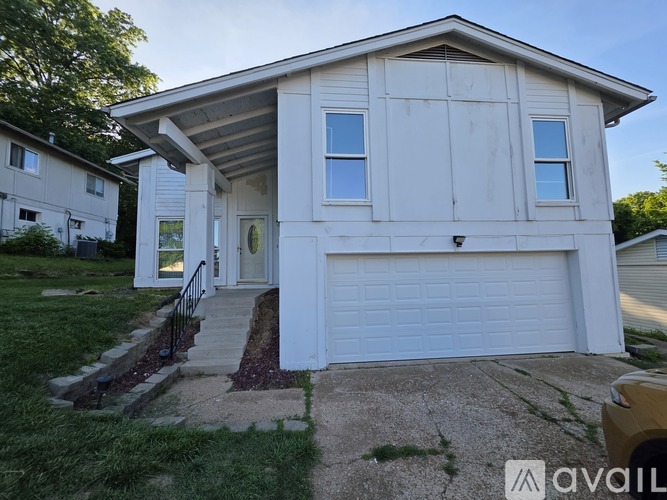 A white house with a garage door and a small front porch.