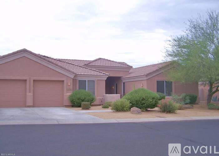 A house with a brown roof and a driveway in front.