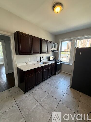 A kitchen with dark brown cabinets and white countertops.