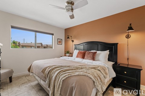 A bedroom with a large bed and a ceiling fan.