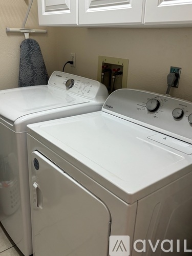 A white washing machine and dryer in a laundry room.