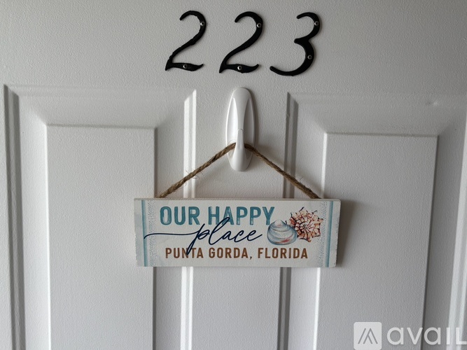 A door with a sign that says "Our Happy Place Punta Gorda, Florida".