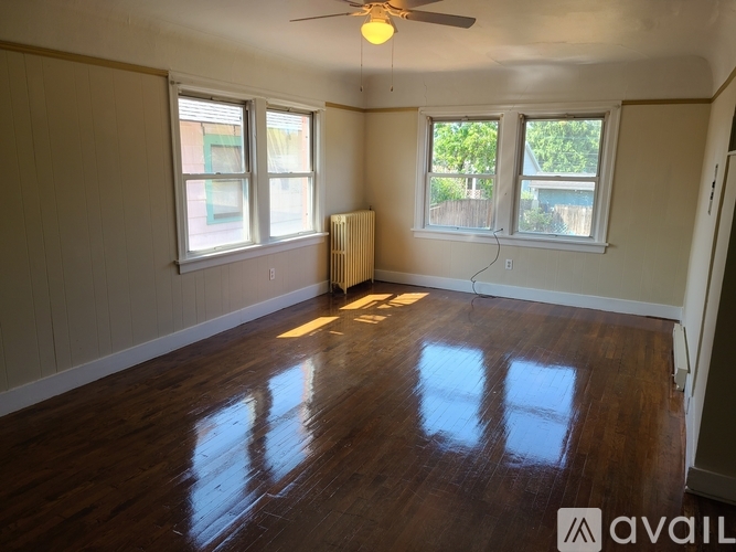 A room with wooden floors and a ceiling fan.