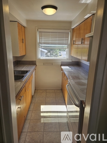 A kitchen with wooden cabinets and a white fridge.