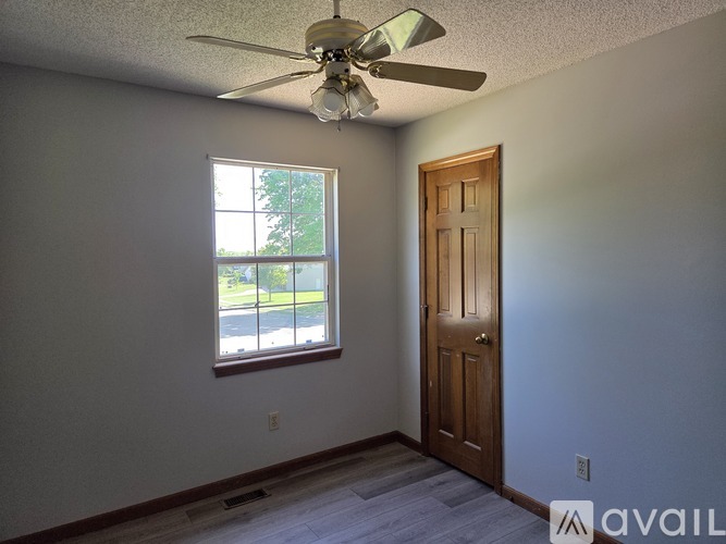 A room with a ceiling fan and a door.