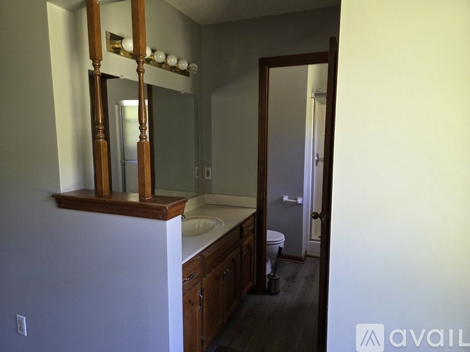 A bathroom with a sink, mirror, and toilet.