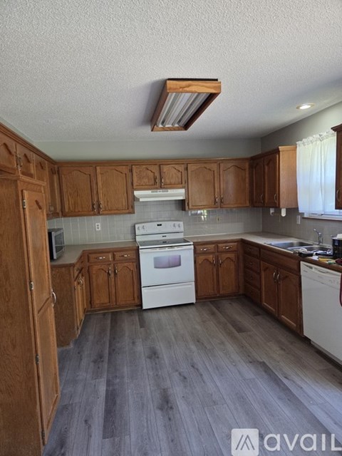 A kitchen with wooden cabinets and a white dishwasher.