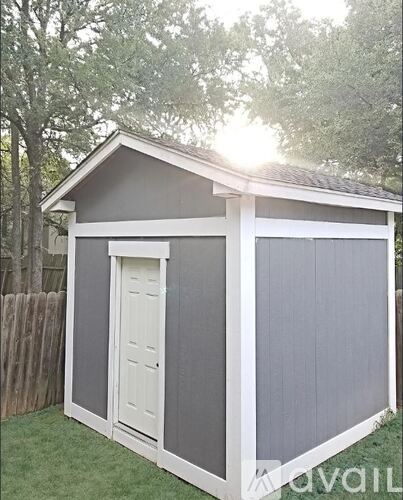 A shed with a grey and white exterior is shown.