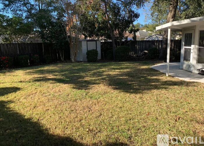 A backyard with a lawn and a house in the background.
