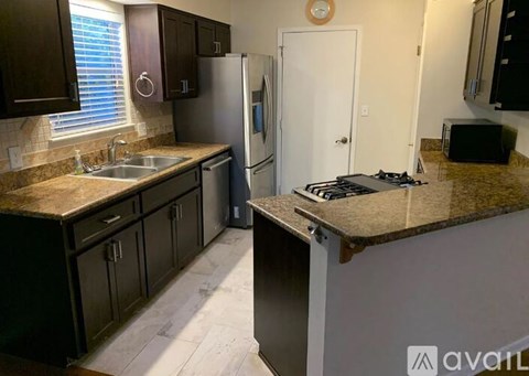 A kitchen with a stove top oven and a refrigerator.