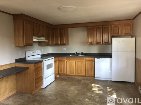 A kitchen with wooden cabinets and a white refrigerator.