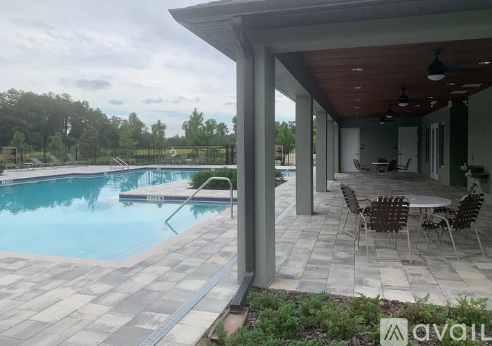 A pool with a patio and a table with chairs.