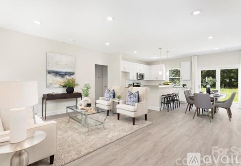 A modern living room with a glass coffee table and a painting on the wall.