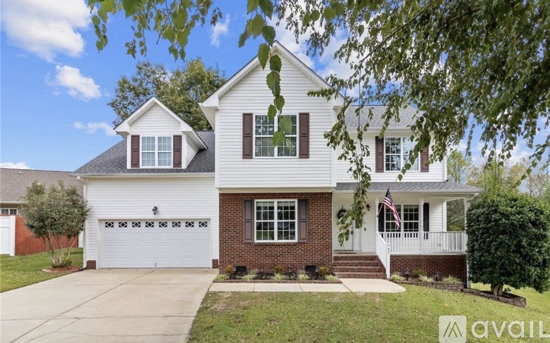 A two-story house with a white garage door and a brick front wall.