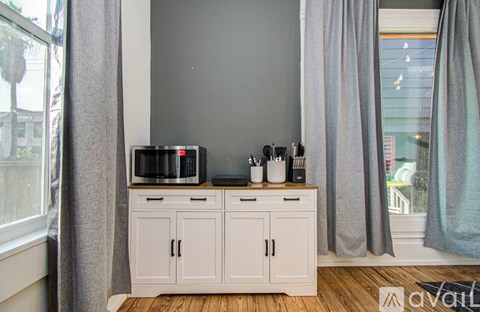 A kitchen with a microwave on top of a cabinet.