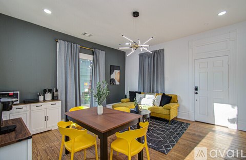 A modern dining room with a wooden table and yellow chairs.