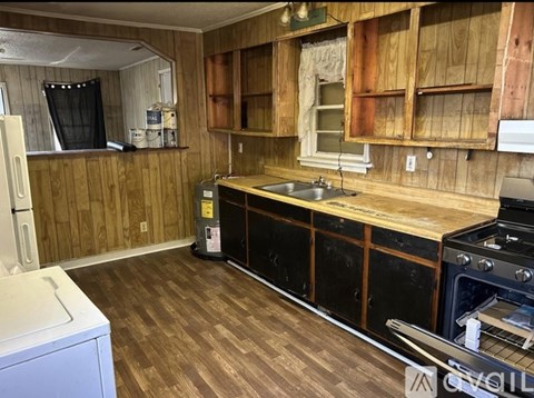 A kitchen with wooden cabinets and a black stove top oven.