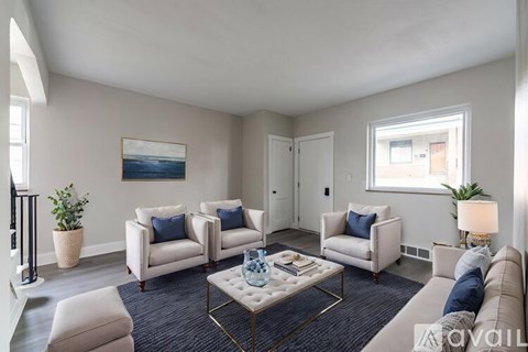 A living room with a white sofa, a white coffee table, and a painting on the wall.