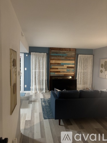 A living room with a couch and a wooden wall panel.