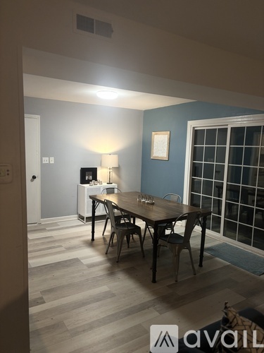 A dining room with a wooden table and chairs.
