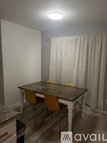 A dining room with a table and chairs.