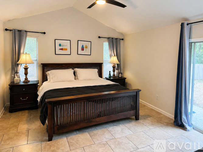 A bedroom with a large bed and two lamps.