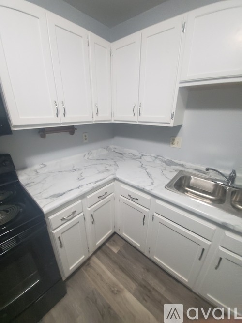 A kitchen with white cabinets and a black oven.