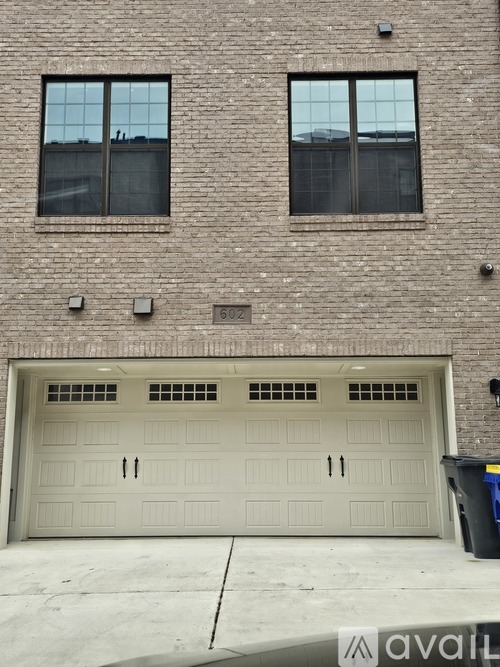 A two-car garage door is in front of a brick building.