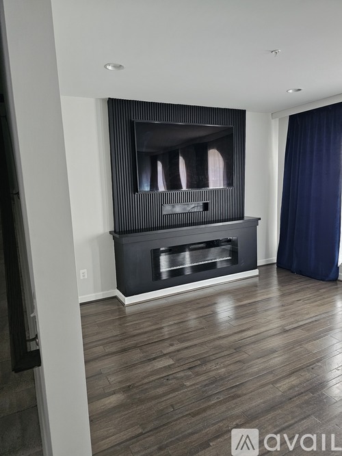 A modern living room with a fireplace and wooden flooring.