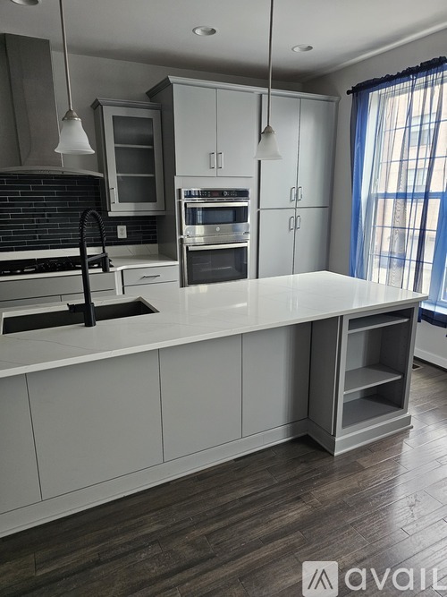 A modern kitchen with a large island and stainless steel appliances.