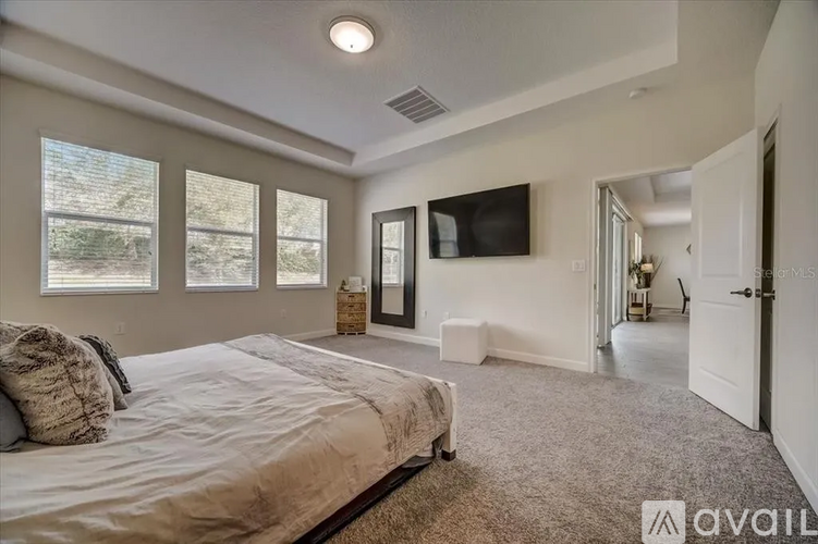 A bedroom with a large bed and a flat screen TV mounted on the wall.