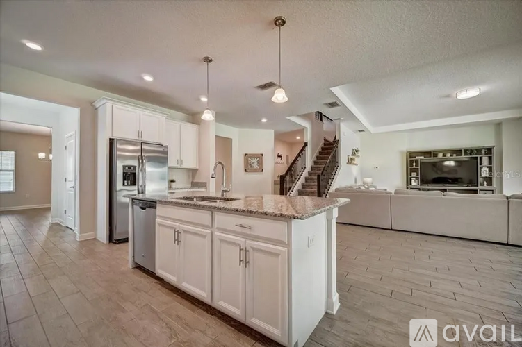 A kitchen with white cabinets and a wooden floor.
