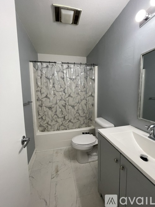 A bathroom with a toilet, sink, and shower.