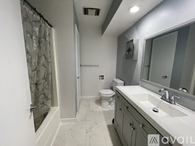 A bathroom with a toilet, sink, and shower.