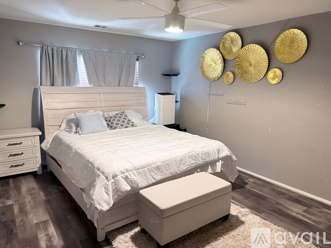A white bedroom with a large bed and a ceiling fan.