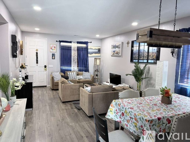 A living room with a couch, chairs, and a dining table set up.