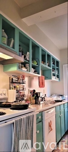 A kitchen with green cabinets and a white stove.
