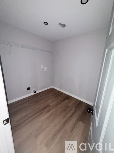 A room with wooden flooring and white walls.