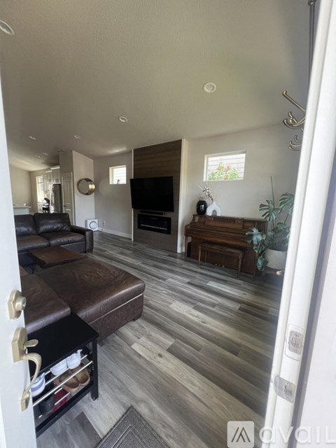 A living room with a brown leather couch and a wooden coffee table.