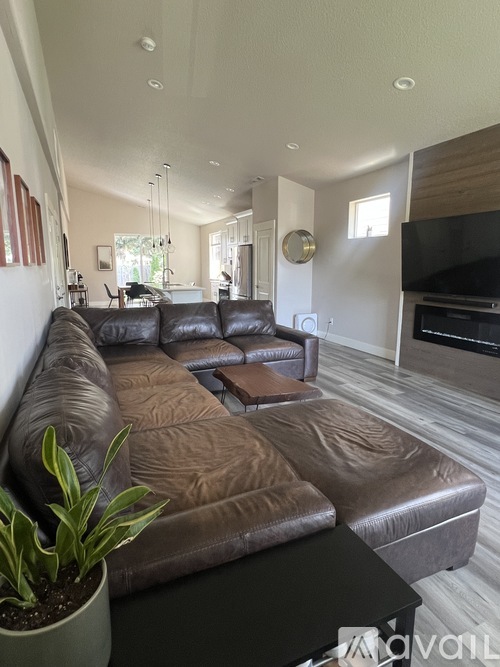 A living room with a brown leather couch and a black coffee table.