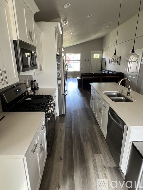 A kitchen with white cabinets and a black stove top.