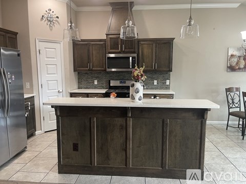 A kitchen with a white counter top and wooden cabinets.