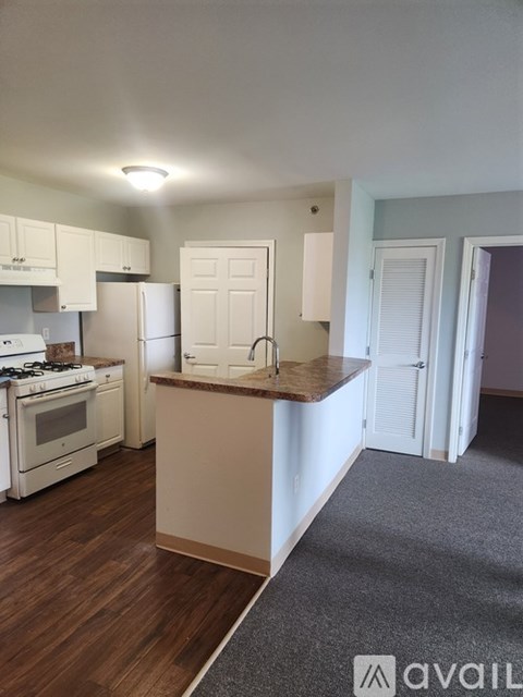 A kitchen with a white stove and cabinets.