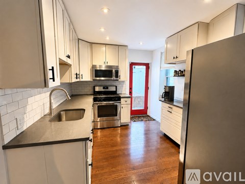 A modern kitchen with a refrigerator on the right side.