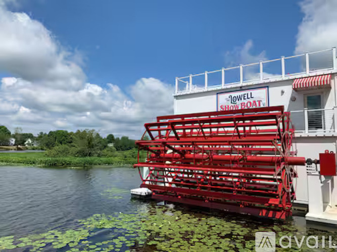 A red boat named "Jowell Show Boat" is docked in a body of water.