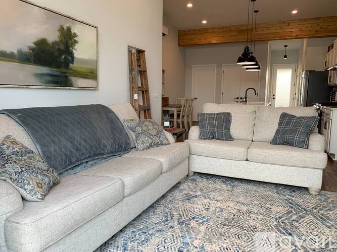 A living room with two couches and a painting on the wall.