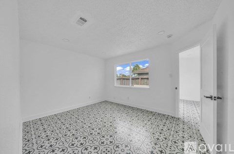 A room with a tiled floor and a window showing a building outside.