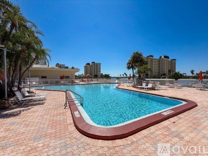A large outdoor swimming pool with a red and brown border.