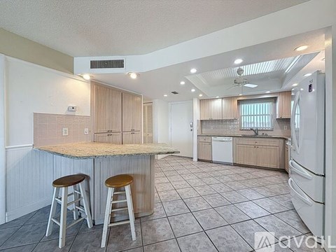 A kitchen with a bar area and a refrigerator.
